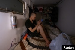 FILE - Lee Kwan Kun, 60, sits in his 'coffin' home in Hong Kong, Aug. 15, 2024.
