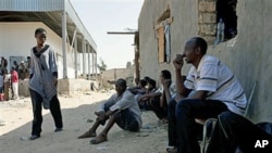 Des immigrants africains se mettent à l'abri des forces du CNT à Tripoli, le 28 août 2011
