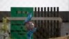 A coronavirus statue stands as workers give final touches to a newly built isolation center in the suburbs of Islamabad, Pakistan, May 12, 2020.