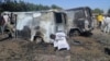 A boy searches the ground next to a burnt-out vehicle, caused by an attack from Boko Haram militants, in Bama, Borno State, Nigeria, Feb. 20, 2014.