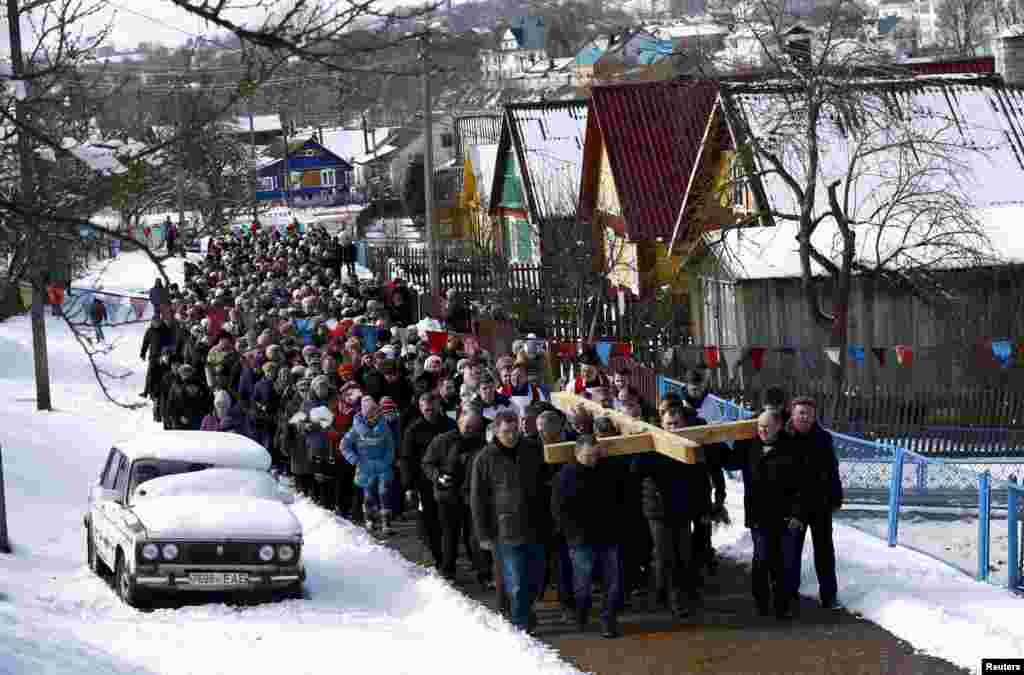 Belarussian Catholics carry a wooden cross as they take part in a procession celebrating Palm Sunday in the town of Oshmiany.