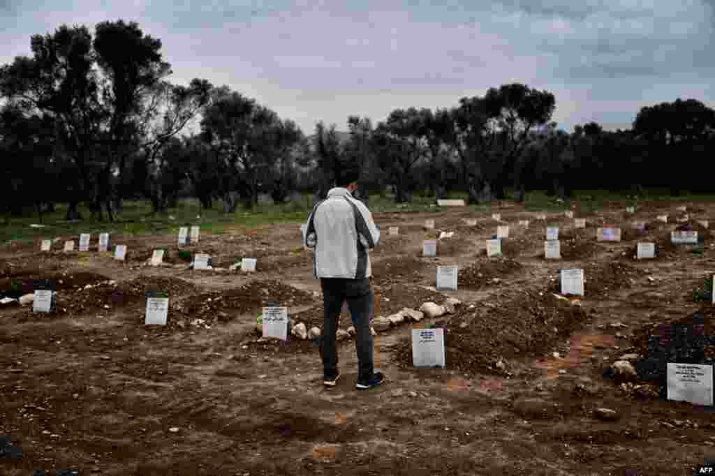 A man looks on at the graveyard in Mytilene, Greece, for refugees and migrants who drowned in their attempt to cross the Aegean sea from Turkey to the island of Lesbos.