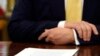FILE - A document sits in front of President Donald Trump on his desk in the Oval Office of the White House in Washington, Oct. 11, 2019.