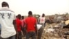 A day after a double bombing in northern Nigeria killed dozens of people, men search the rubble for bodies in Maidguri, March 2, 2014. (Abdulkareem Haruna/VOA)