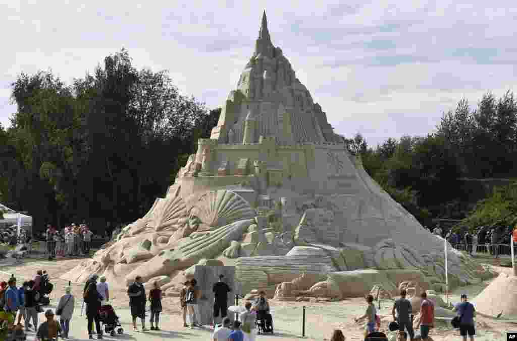 Orang-orang menyaksikan istana pasir raksasa di Duisburg, Jerman, Jum&rsquo;at, 2 September 2016.&nbsp; Istana pasir tersebut menghabiskan 2.300 ton pasir.