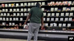 A shopper checks out nearly empty shelves in the lunch meat section of a Walmart, Sept. 25, 2024 in Tallahassee, Florida. A nationwide recall of meat and poultry products potentially contaminated with listeria has expanded to nearly 12 million pounds, Oct. 16, 2024. 