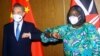 Chinese Foreign Minister Wang Yi and his Kenyan counterpart, Raychelle Omamo, bump elbows during a news conference in Mombasa, Kenya, Jan. 6, 2022. 