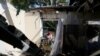 FILE - A local resident removes debris inside a house, which locals said was damaged during recent shelling, in the rebel-controlled city of Donetsk, Ukraine, June 17, 2019. 