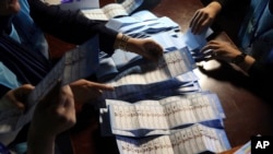 Election workers count ballots at a polling station in Kabul, Afghanistan, Sept. 28, 2019. 