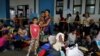 FILE - A Venezuelan migrant woman poses for a picture with her children, while they wait to have their documents processed at the Ecuador-Peru border, on the outskirts of Tumbes, Peru, June 17, 2019.