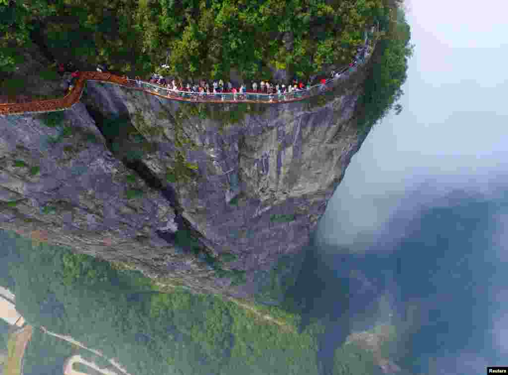 Para pengunjung berjalan di lokasi observasi pemandangan di bukit kota Zhangjiajie, Hunan, China.