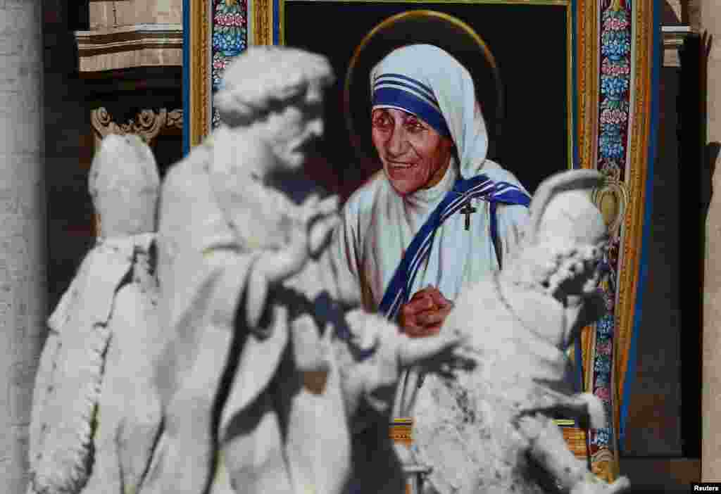 Sebuah permadani hiasan dinding yang menggambarkan Bunda Teresa dipasang di depan Basilika Santo Petrus selama misa oleh Paus Fransiskus, untuk kanonisasi Teresa di Lapangan Santo Petrus di Vatikan (4/9). (Reuters/Stefano Rellandini)