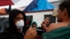 FILE - Mexican Health Ministry representatives give migrants free shots for the flu, hepatitis B, tetanus, and preventible children's diseases at the Barretal shelter for migrants in Tijuana, Mexico, Dec. 6, 2018.