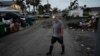 Robert Turick, 68, walks on his street as he and other neighbors work to remove debris swept onto their properties by Hurricane Milton's storm surge, in Englewood, Florida, on Oct. 11, 2024.