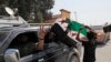Members of Turkey-backed Syrian National Army (former FSA) flash the V-sign as they drive back to Turkey near the border between Turkey and Syria, in Akcakale, Sanliurfa province, southeastern Turkey, Oct. 9, 2019. 