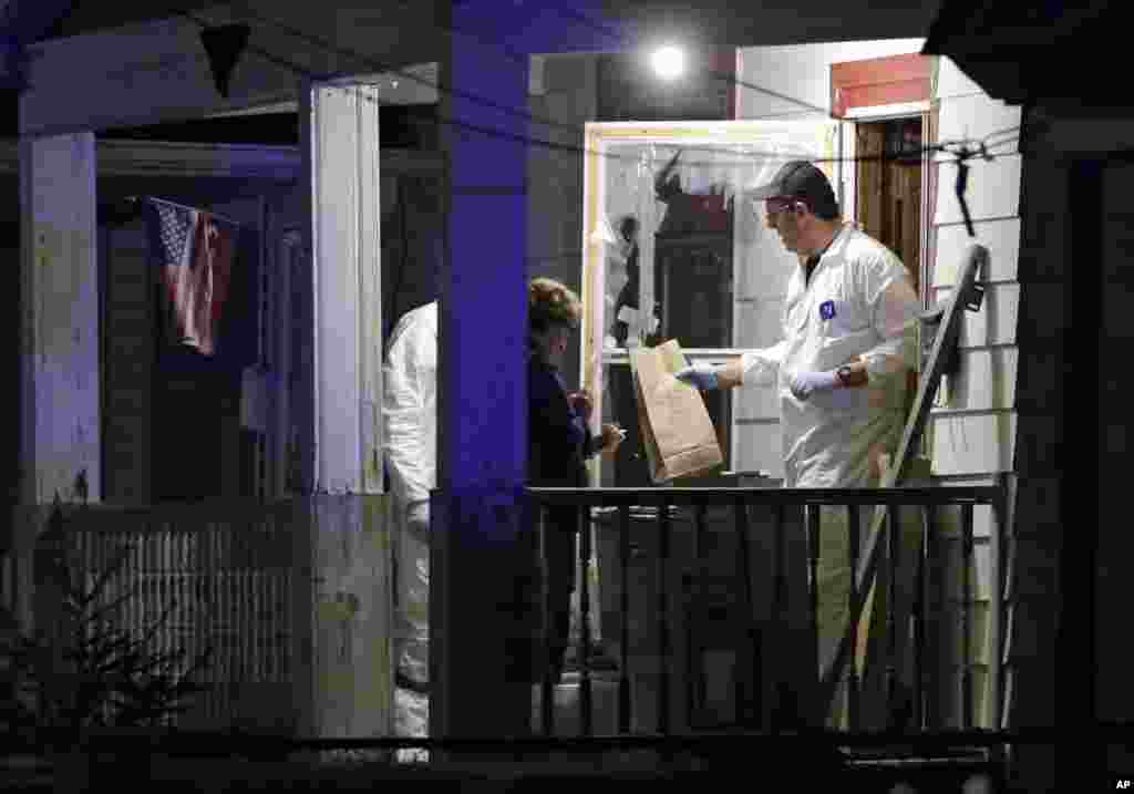Para anggota tim FBI mengumpulkan bukti-bukti dari sebuah rumah tempat tiga perempuan yang hilang ditemukan di Cleveland, Ohio (6/5). (AP/Mark Duncan)