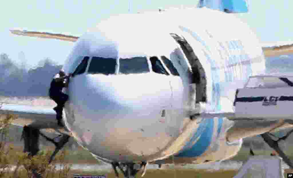 A man, leaves the hijacked aircraft of Egyptair from the pilot&#39;s window after landing at Larnaca airport in Cyprus. The plane was hijacked while flying from the Egyptian Mediterranean coastal city of Alexandria to the capital, Cairo, and later landed in Cyprus where some of the women and children were allowed to get off the aircraft, according to Egyptian and Cypriot officials. The hijacker was arrested later after hours of negotiations.