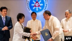 Japanska ministrica vanjskih poslova Yoko Kamikawa i filipinski ministar odbrane Gilberto Teodoro rukuju se nakon potpisivanja Sporazuma o recipročnom pristupu u palači Malacanang u Manili 8. jula 2024. godine.