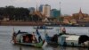 Fishermen row their wooden boats at a conjunction of rivers between the Mekong River and Tonle Sap as they catch fish during the fish harvesting season near Phnom Penh, Cambodia, Wednesday, Nov. 28, 2018. (AP Photo/Heng Sinith)