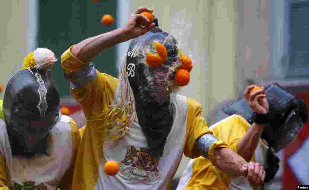 A participant is hit by an orange during an annual carnival battle in the northern Italian town of Ivrea, Italy.