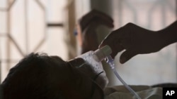 Un parent ajuste le masque à oxygène d'un patient tuberculeux dans un hôpital des tuberculeux à l'occasion de la Journée mondiale de la tuberculose à Hyderabad, en Inde, le samedi 24 mars 2018. 