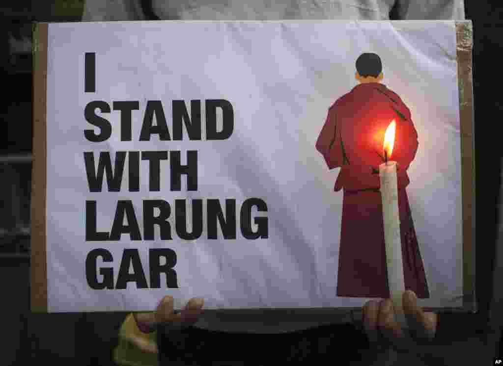 1 An exiled Tibetan holds a placard as he participates in a protest in Dharmsala, India, against the demolition of buildings in Larung Gar by Chinese authorities. Larung Gar is an area in eastern Tibet housing Buddhist institutions and thousands of monks and nuns.
