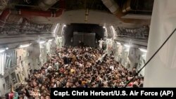 Un avion militaire américain avec des centaines d'Afghans qui fuient le pays.