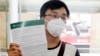 Passenger Kevin Ouyan shows an information pamphlet he was given on arrival at Sydney airport in Sydney, Jan. 23, 2020, on a flight from Wuhan, China. 
