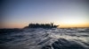 FILE - Migrants and refugees from various African countries aboard a wooden boat in the Mediterranean Sea. 