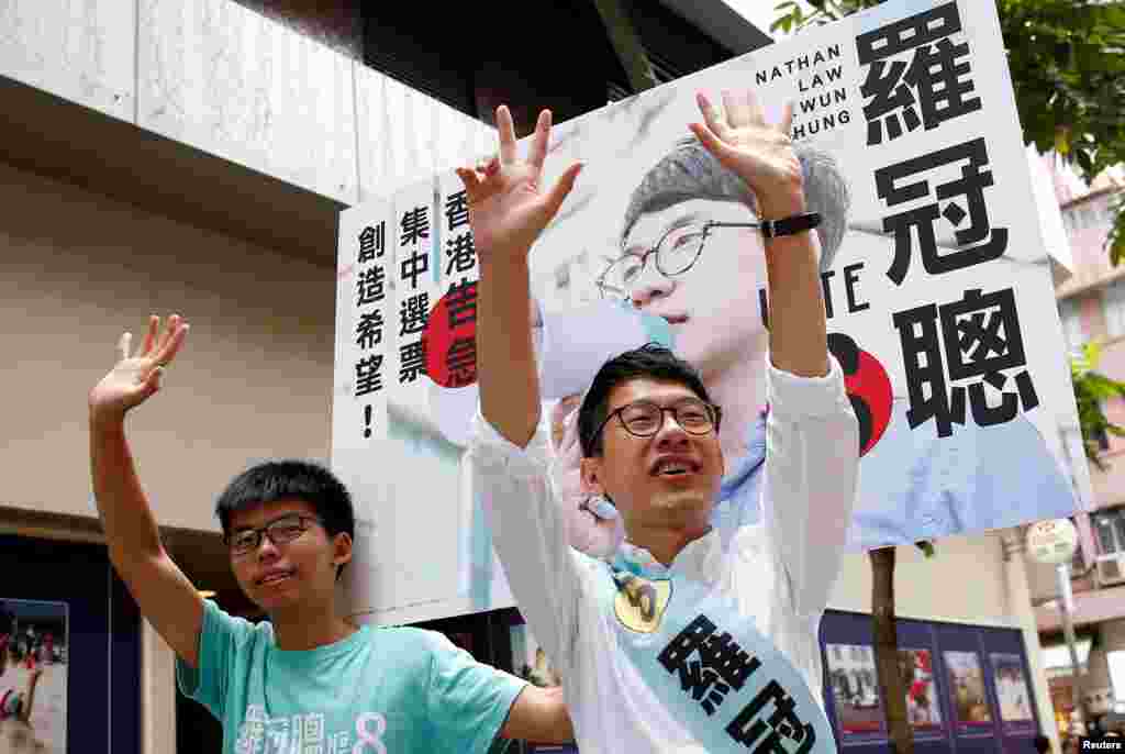 Nathan Law (kanan), caleg dari &#39;Demosisto&#39; didampingi aktivis mahasiswa Joshua Wong menyalami para pendukungnya, pada pemilu Dewan Legislatif di Hong Kong, China.