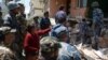 Nepalese resident Sangita Mahat, center, directs police as they retrieve the body of her relative Prasamsah, 14, during rescue efforts in Balaju in Kathmandu, April 27, 2015. 