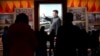 资料图：在北京的中国共产党历史展览馆，参观者从习近平的图片前走过（2021年11月11日）