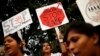 FILE - Indian physiotherapy students hold placards at a rally on the 1st anniversary of the fatal gang rape of a young woman in a bus New Delhi, India.