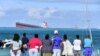 Des passants regardent le vraquier MV Wakashio qui s'était échoué près du parc marin de Blue Bay, dans le sud-est de l'île Maurice, le 6 août 2020. (Photo: Dev Ramkhelawon / L'Express Maurice / AFP)