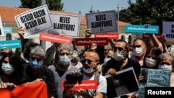 FILE - Media workers, holding signs reading "We can't breathe" protest government pressure on free speech and independent media, during a rally in Istanbul, Turkey, June 29, 2021. 