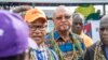 Bougainville regional president John Momis, left, speaks to the media before casting his ballot in an historical independence vote as the Papua New Guinea minister for Bougainville affairs, Puka Temu, center, looks on in Buka on Nov. 23, 2019. 