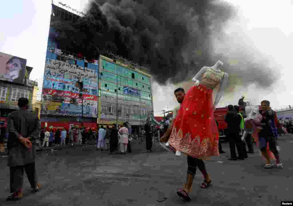 Seorang pria Afghanistan menyelamatkan sebuah&nbsp;mannequin setelah kebakaran melanda sebuah pusat perbelanjaan di Kabul.