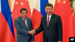 中国国家主席习近平在北京人大会堂与参加一带一路峰会的菲律宾总统杜特尔特握手。（2017年5月15日）