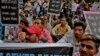 FILE - Sewer cleaning workers and others sit during a protest near the Indian parliament calling for safer working conditions following the deaths of several sanitation employees, in New Delhi, India, Sept.25, 2018.