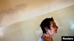 FILE - A patient is seen walking toward a group therapy room at a mental health institution in the Balkans.