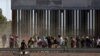 FILE - Migrants queue to request asylum after crossing illegally into El Paso, in this picture taken from Ciudad Juarez, Mexico, April 21, 2019.