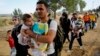 Syrian refugees walk toward a crossing point at Greece's border with Macedonia, near the Greek village of Idomeni, Sept. 8, 2015.