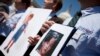 FILE - Fathers who lost their children to spousal abduction to Japan hold photos of their children during a news conference on Capitol Hill in Washington, May 5, 2010 In 2013, Japan’s parliament approved joining the 1980 Hague Convention on international child abduction, a global child custody treaty, amid foreign concerns that Japanese mothers can take children away from foreign fathers without recourse. 