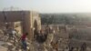 FILE - In this July 24, 2014 file photo, people walk on the rubble of the destroyed Mosque of The Prophet Younis, or Jonah, in Mosul, 225 miles (360 kilometers) northwest of Baghdad, Iraq. 