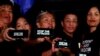 FILE - Journalists, including Rappler CEO Maria Ressa, raise their smart phones with words "STOP THE ATTACKS!" in a rally for press freedom in Quezon City, Philippines, Feb. 15, 2019. 