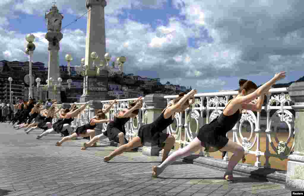 Ballet dancers perform an outside routine, as part of the Month of Dance in San Sebastian, in front of Concha Bay, Spain.