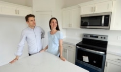 In this April 27, 2019, photo, millennials Andy and Stacie Proctor in the kitchen of their new home in Vineyard, Utah.