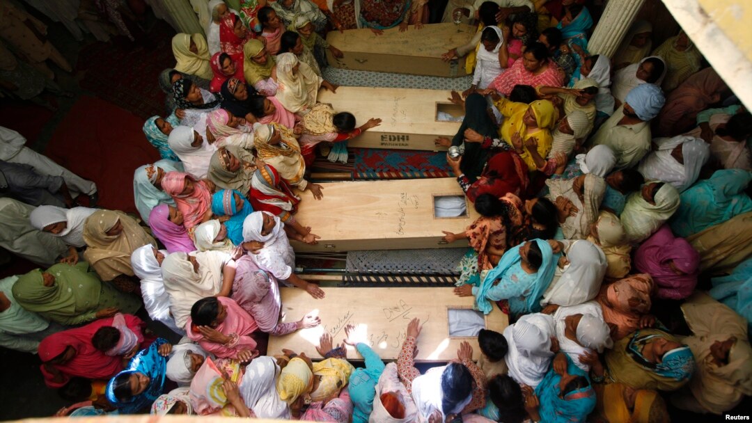 Relatives of seventeen children who died after a gas cylinder exploded on a school bus, mourn over their coffins, on the outskirts of Gujrat, 100 miles (170 km) southeast of Islamabad, May 25, 2013. The children were on their way to school when the incide