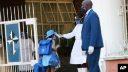 A student has her temperature checked, at the entrance of a private school in Harare, Zimbabwe, Sept. 14, 2020.