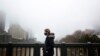 A person in a protective face mask walks along the Princes Bridge amidst a lockdown in response to an outbreak of the coronavirus disease (COVID-19) in Melbourne, Australia, July 17, 2020. (AAP Image/Daniel Pockett via Reuters)